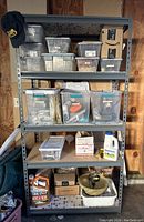 Full view of four-tier metal shelving holding labeled storage bins, garden chemicals, fertilizer bag, and a black cap.