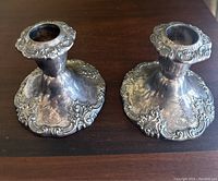 Pair of vintage Wallace Baroque style silver plated candlestick holders showing top and sides with detailed ornate patterns and some tarnish.