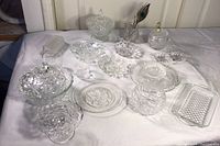 Overview showing the collection of clear crystal and cut glass serving pieces, various shapes and patterns visible.