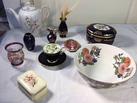 Wide view showing all items including Royal Duchess teapot, alabaster box, ceramic boxes, vase with wheat, serving bowl, decorative plaques, and small vases.