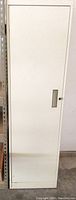 Front view of white metal locker cabinet with closed door and recessed handle