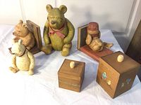 Full shot showing two Winnie the Pooh resin bookends, Winnie the Pooh resin figure, and two wooden storage boxes.