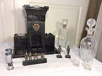 Photo showing the wooden castle bar storage with glassware, decanters, and figurines arranged in front.
