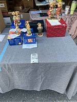Five figurines arranged on table with boxes and certificates
