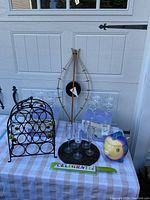 Full lot with margarita glasses, wine rack, plastic champagne glasses, fish cookie jar, clock, and cake cutter