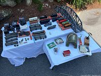Overview of trains, cars, track, controllers, bridge, tunnel, and scenery on display