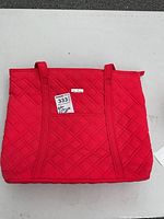 Overall front view of the red Vera Bradley quilted tote bag showing its quilted diamond pattern and shoulder straps.