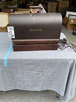 Full view of the vintage Singer sewing machine inside its closed carrying case placed on a table.