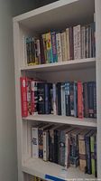 Bookshelf with various hardcover and paperback books including Britannia, Americana, and educational titles