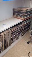 Shelves with stacks of vinyl LPs showing top and bottom rows of record sleeves