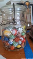 Clear Ball glass jar filled with colorful assorted glass marbles, showcasing colors and jar details