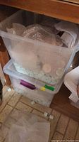 Two plastic totes filled with bubble wrap enclosing china pieces