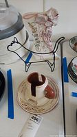 Wooden paper towel holder with round handle, metal cat-shaped wire stand, pottery plate and cup with floral decoration