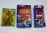 Front view of the three sealed figurines including the Scooby Doo figure in blister card and two Sailor Moon Adventure Dolls in boxes.