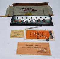 Photo showing the Lightning Adding Machine inside its original cardboard box along with the stylus, instruction manual, and guarantee certificate.