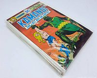 Stack of Kamandi comics sealed in poly bags with backing boards, showing the cover of one issue.