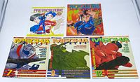 Photo of 5 anime/manga magazines: 2 Protoculture Addicts and 3 Mecha Press issues, showing front covers with colorful anime and mecha images.