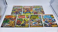 Display of seven Marvel Triple Action comic books laid out in two rows showing their vibrant cover art and condition