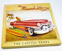 Front cover of The Beach Boys The Capitol Years 7LP box set showing red convertible and surfboards on beach scene.