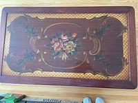 Top view showing detailed floral inlay design on the wooden tabletop with decorative border.