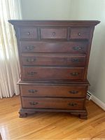 Full front view of the assembled tallboy dresser showing three small upper drawers and two large lower drawers with traditional metal handles and carved feet.