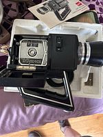 GAF ST-111E Super 8 movie camera opened to show film compartment and control dial.