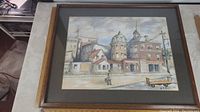 Full framed watercolour artwork showing a street scene with historical buildings including the Canada Hotel.