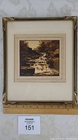 Framed woodcut print measuring approximately 12 x 10.5 inches with a wood frame showing a waterfall over rocks.