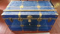 Top front view of a blue metal storage trunk with a measuring stick showing dimensions 35 inches length, 19.5 inches depth, 19 inches height