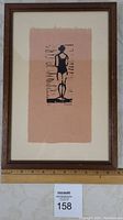 Framed artwork showing full view of the linocut print 'The Bather' by Tatham with a ruler for scale.