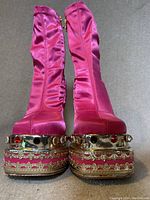Front view of pink satin platform heels showing jewel and gold accents on platform and heel
