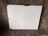 View of the table top showing its rectangular shape, foldable nature, and slightly rounded corners with minor surface wear.