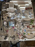 Overview of all plumbing items laid out on a table showing PVC pipes, fittings, hoses, clamps, valves, and faucets.