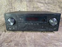 Front view of Pioneer audio receiver showing control knobs, display, and Pioneer branding