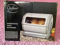 Box front showing Crofton Horizontal Twin Rotisserie Oven with photo of appliance and key features listed
