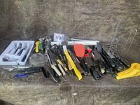 Wide view of all kitchen utensils including knives, spatulas, peelers, tongs, and scoops set on a fabric surface