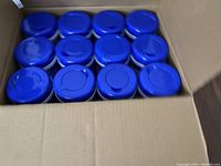 12 blue and white containers of sanitizing wipes inside a cardboard box.
