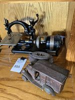 Wilcox and Gibbs antique sewing machine with motor attachment, vintage rusty iron delivery car in front