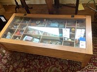 Full view of wooden coffee table with glass top revealing compartment display