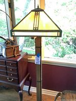 Full view of floor lamp with stained glass shade and wooden column