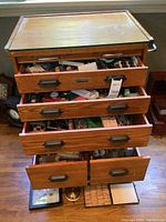 Full view of oak cabinet on wheels with five drawers open showing contents