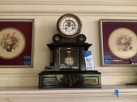 Overall view: marble clock centered between two framed floral prints