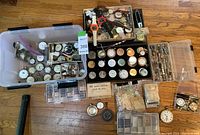 Overview of entire lot: plastic tub of loose movements, black tray, small boxes, tools