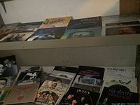 Shelves showing multiple vinyl LP albums including the Grease soundtrack, Queen, and others arranged neatly.