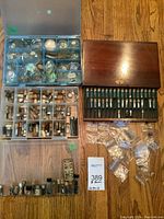 Overhead view of wooden tray and multiple plastic organizers filled with watch parts