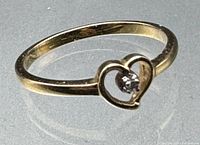 Single 10K gold ring showing heart shape with small stone from top angle