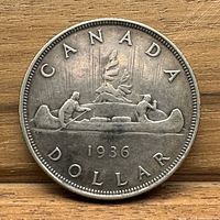 Reverse side of the coin showing two voyageurs in a canoe and inscription.