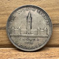 Reverse side of the 1939 Canadian silver dollar featuring Canadian Parliament Buildings with inscriptions.