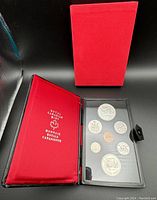 Set of 1974 Canadian coins in a black presentation book with red lining and protective red outer sleeve. Coins displayed in a protective plastic panel inside the book.