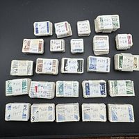 Photo shows tightly wrapped bundles of old Canadian stamps, each labeled with catalogue numbers and years ranging mostly from 1956 to 1966.